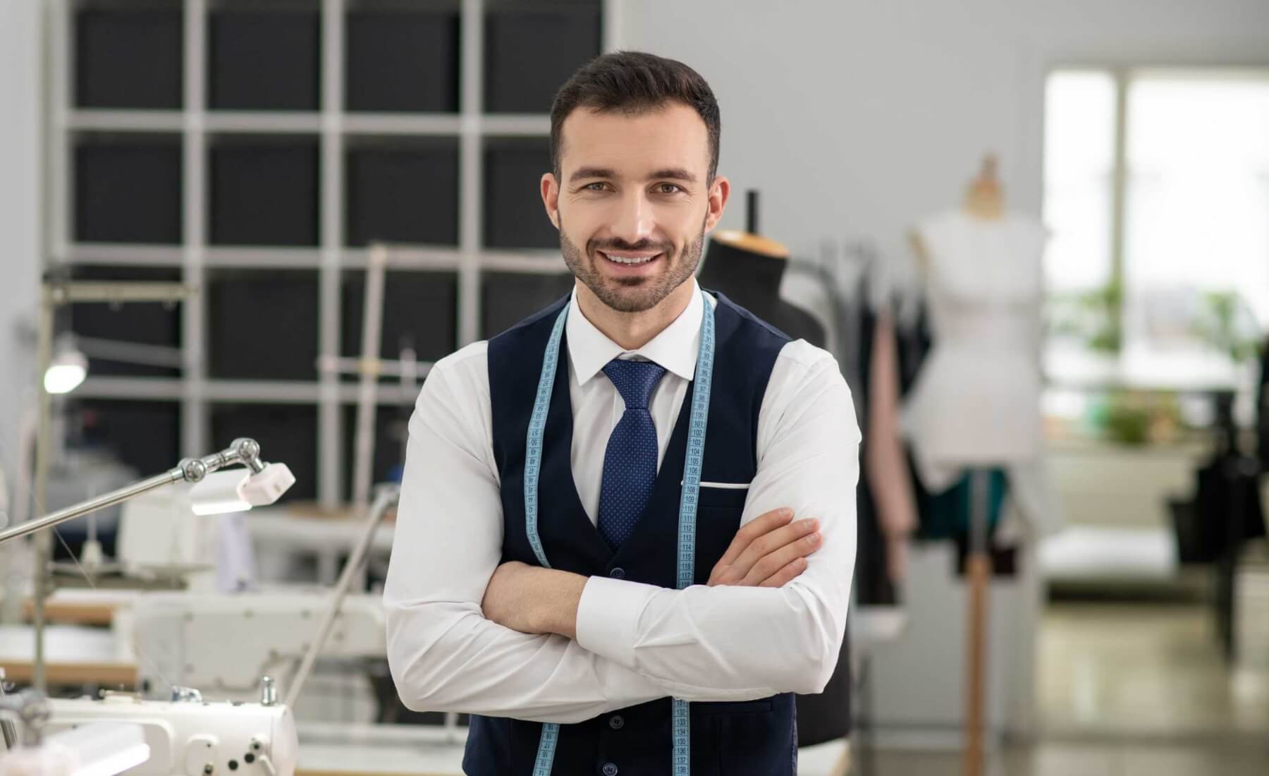 male tailor standing with folded hands smiling 6XDBDYM