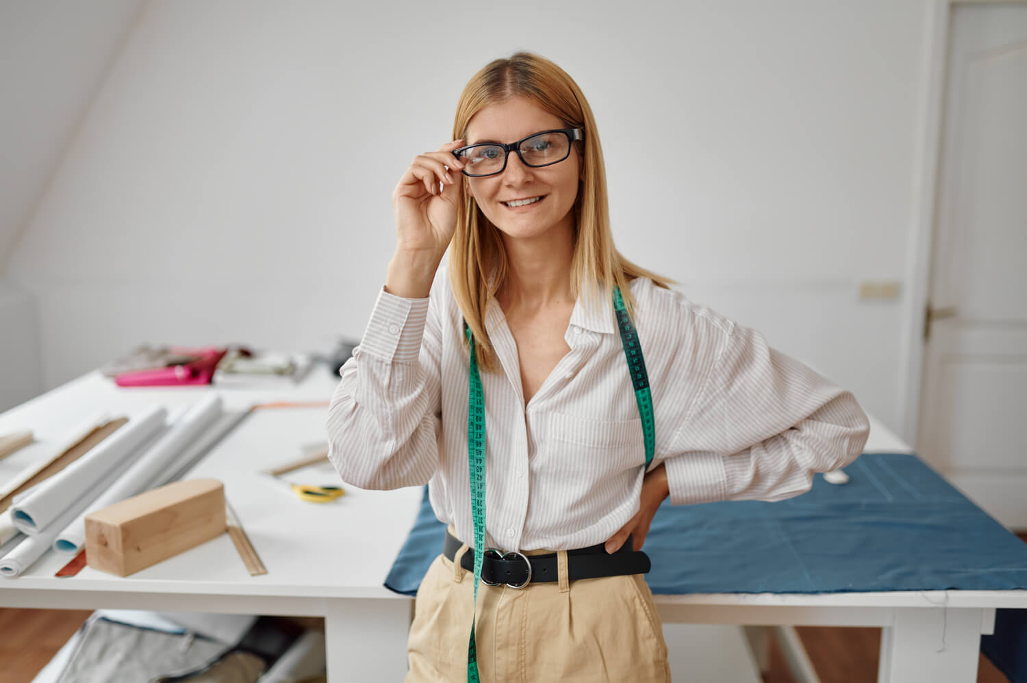 seamstress in glasses at her workplace in workshop LGEPNAG