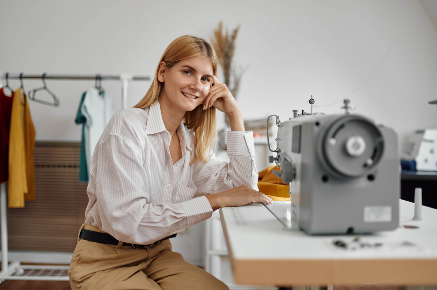 seamstress works on sewing machine at workplace 5A8NBHL